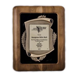 Walnut frame plaque with gold scroll casting on black velour backdrop